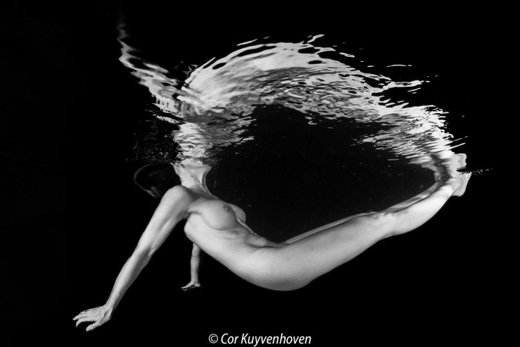 Vrouw-naakt-spiegelbeeld-zwartwit onderwater in een zwembad Naakte vrouw onderwatershoot