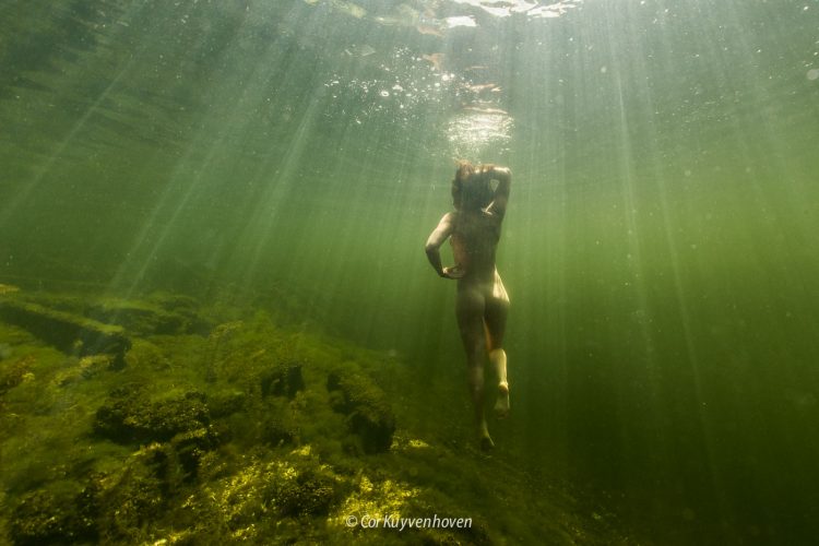 Vrouw-zonnestralen-natuurwater-naakt