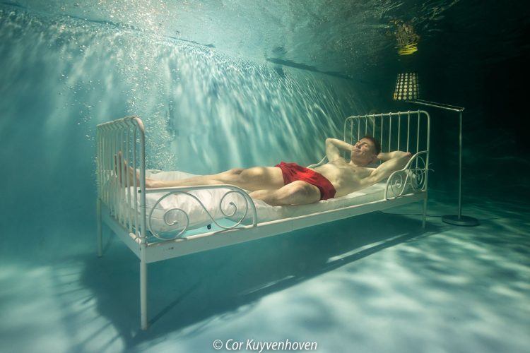 Bed met man onder water in zwembad