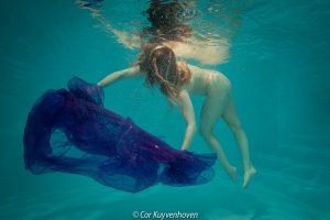 Blote vrouw onderwater in zwembad
