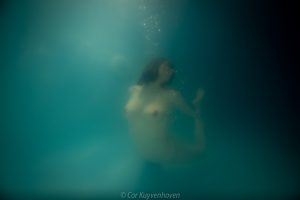 Naakte vrouw onderwater in de mist