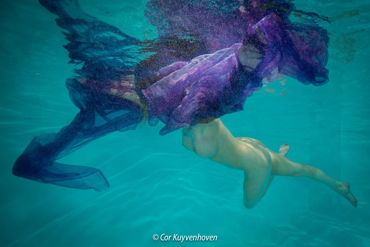 Naakte vrouw in zwembad met een doek om haar hoofd