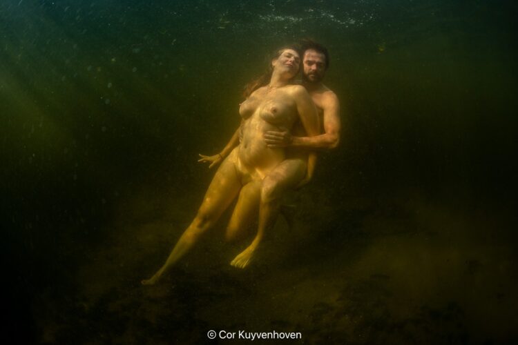 Unieke onderwaterfotografie van naaktkoppels in natuurlijke wateromgeving, samenwerkend in een kunstzinnig waterlandschap.